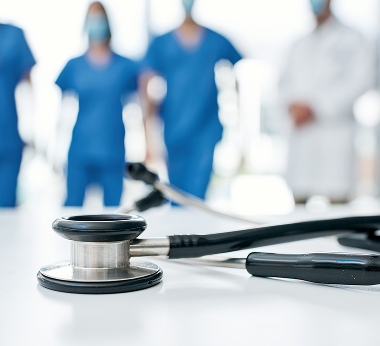 Stethoscope with a healthcare team in the background